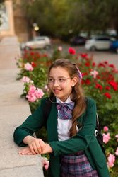 Girl in school uniform surrounded by blooming flowers.