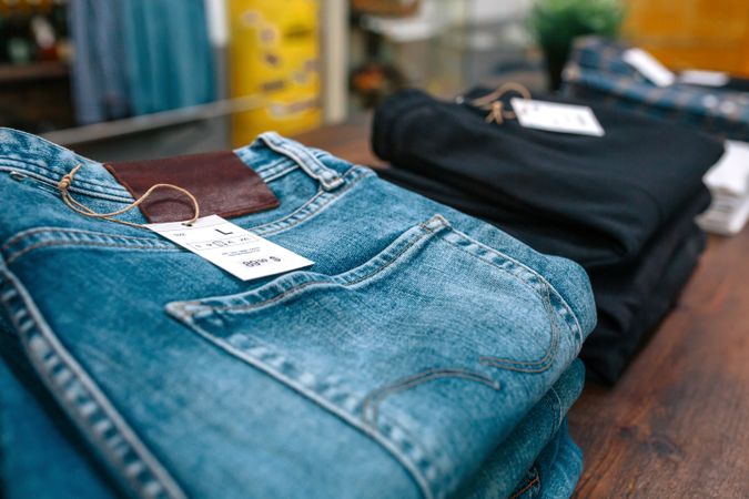 Detail of label with price and size over a blue jeans pants on industrial style store.