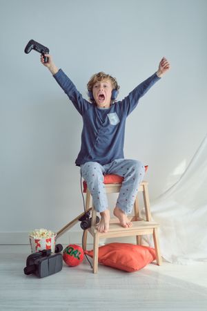 Excited boy playing video game with controller