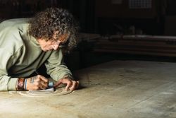 Male carpenter creating sketch in notebook in workshop