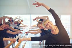 Group of women stretching at barre in dance studio 0WrArb