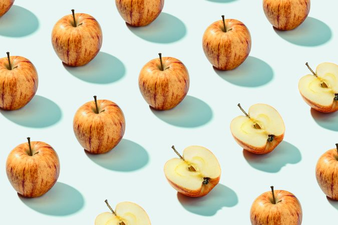 Half apple in row with whole apples