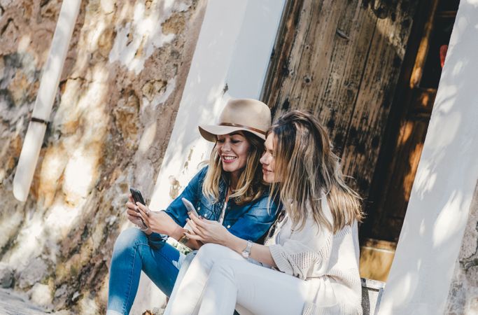 Friends sitting hugging and smiling with smartphone