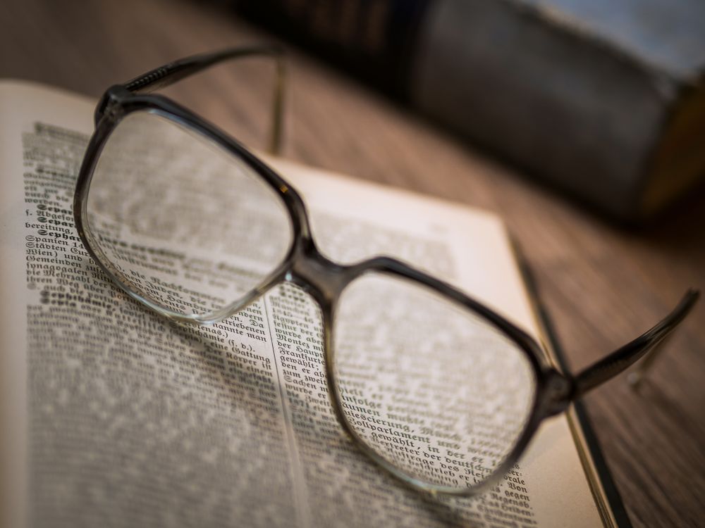 Framed eyeglasses on book page
