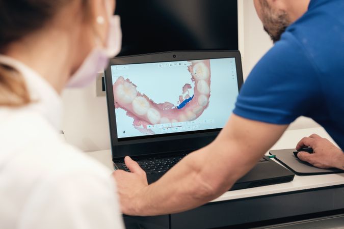 Unrecognizable dentists examining 3D teeth scan