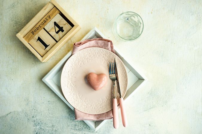 Table setting for Valentine's day with pink plates and heart decoration