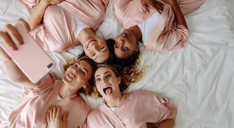 Top view of bride taking selfie with bridesmaids making funny faces