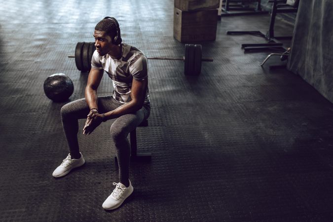 Athlete relaxing after workout sitting on a bench in the gym