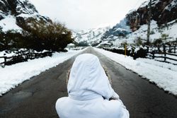 Anonymous person standing on road in countryside