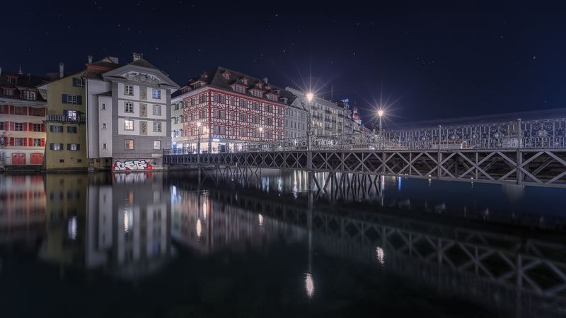 Illuminated buildings on city embankment in night