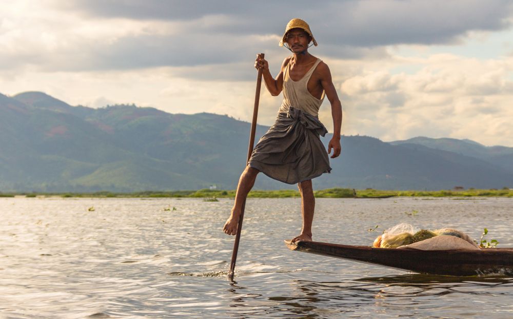 Shan, Myanmar - June, 25 2012: Anonymous fisherman standing on boat