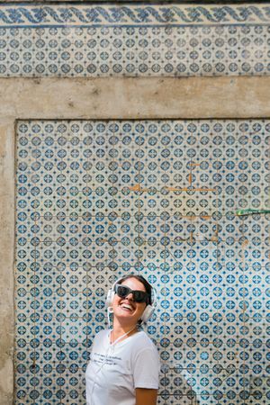 Cheerful casual woman in sunglasses standing on city street
