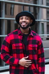 Cheerful Black man in stylish outfit on street