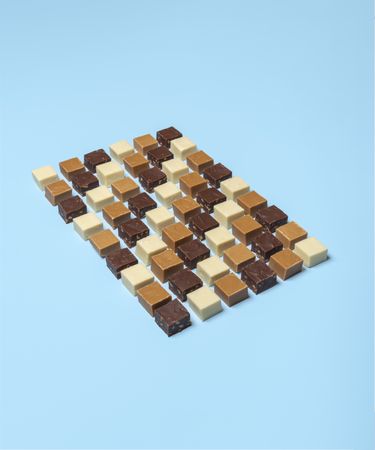 Homemade fudge pieces aligned over a blue background