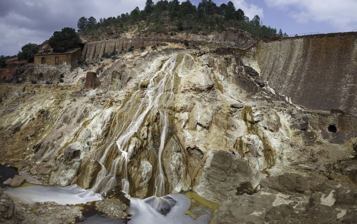 Stream flowing on sandy rock on sunny day