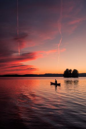 Silhouette of person on boat during sunset