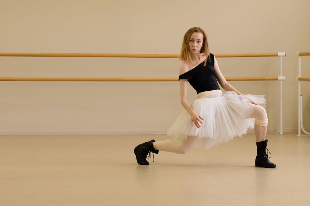 Ballerina in shoes and tutu, extending leg