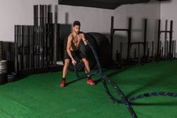 Man training with ropes in gym