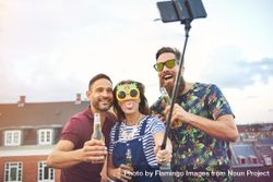 Group of friends with selfie stick, woman in center sticking her tongue out 5w66m0