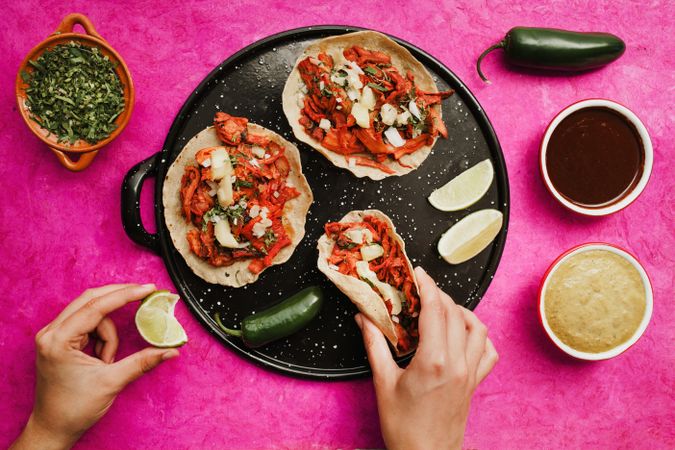 Crop hand holding taco al pastor