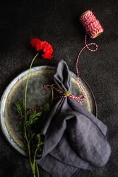 Rustic table setting with poppy flower and red string