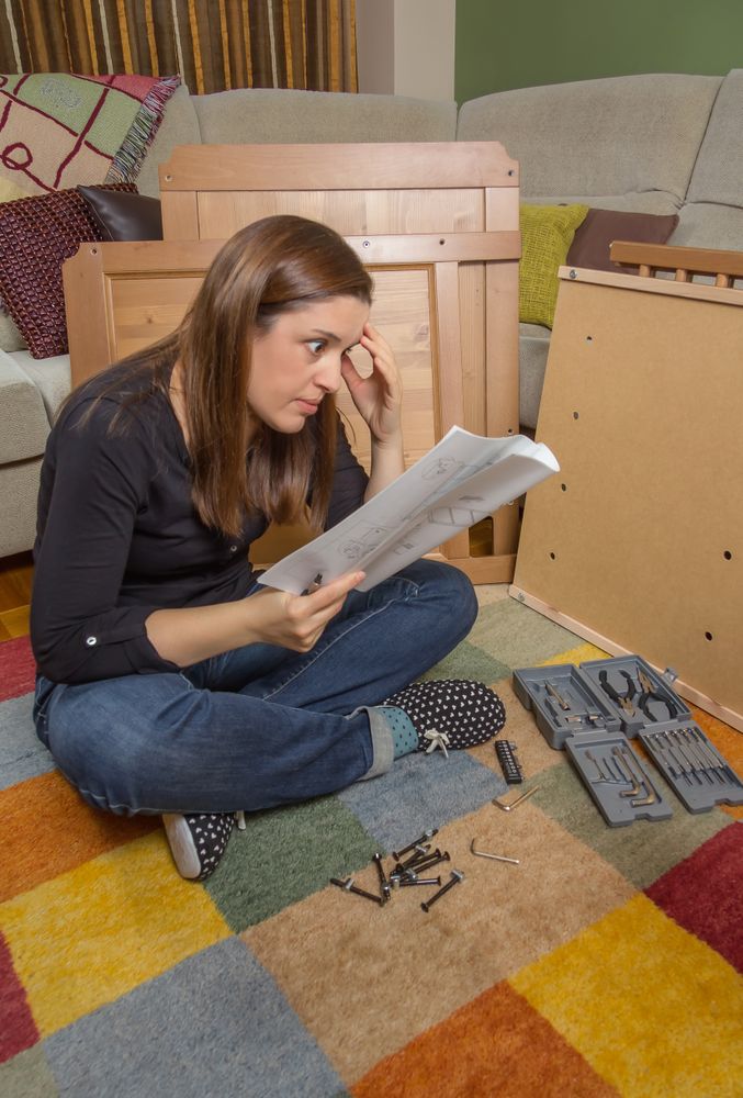 Woman reading instructions to assemble furniture
