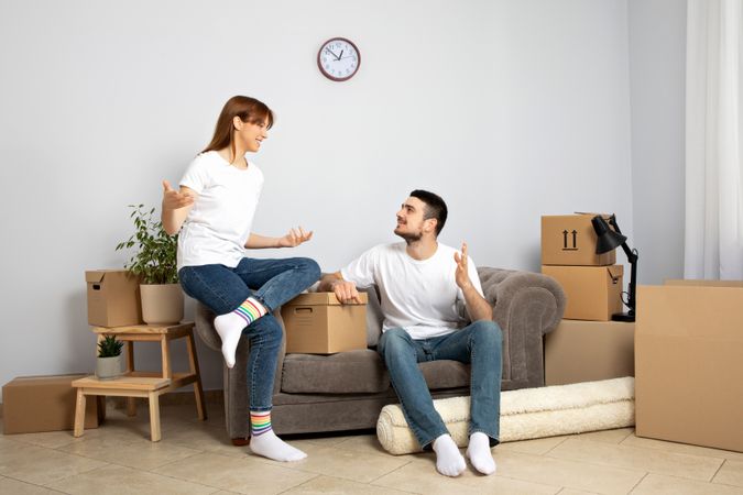 Moving concept, couple man and woman with boxes in apartment.