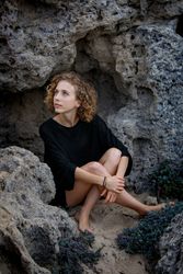 Young woman sitting between stones