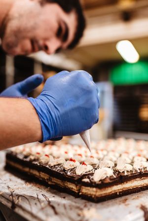 Crop baker squeezing dough on tray