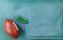 American football on cleaned chalkboard with writing supplies 4AzmBW