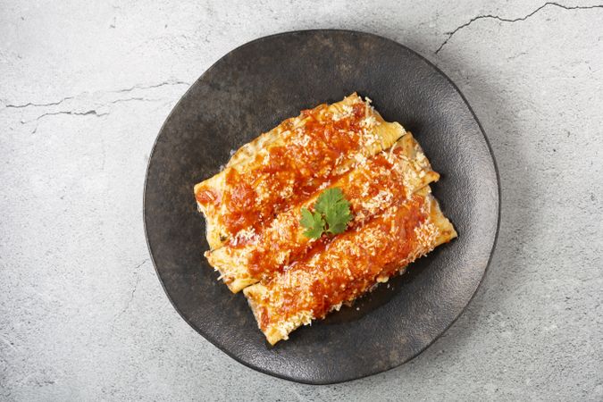 Pancakes stuffed with minced meat and topped with tomato sauce and grated cheese.