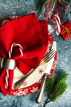 Christmas dinner concept with seasonal red plate and candy cane decor