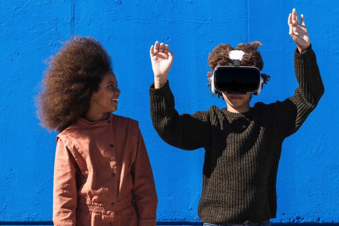 Black kids with VR headset getting experience with virtual world