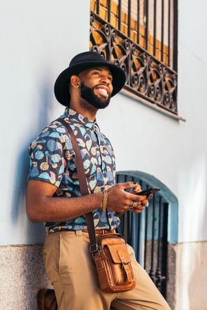 Stylish Black man using smartphone outdoors in the city