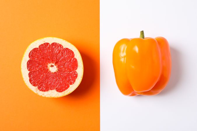 Grapefruit and pepper on two tone background, space for text