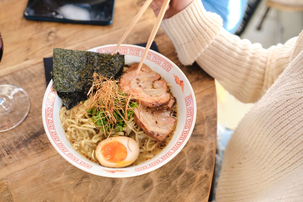 Faceless person eating delicious asian noodles
