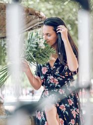 Young female smelling bouquet of flowers resting in park