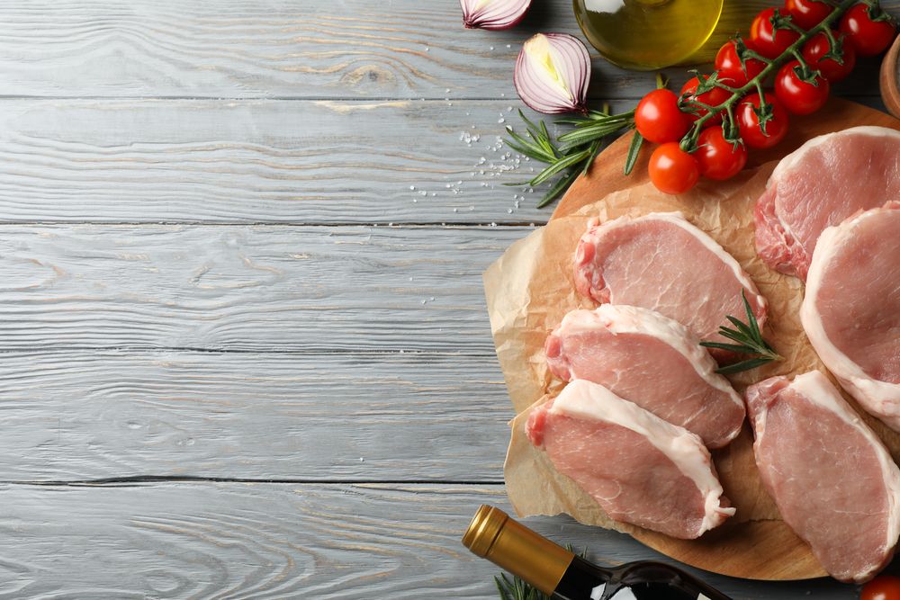 Composition with raw meat for steak and ingredients on wooden background