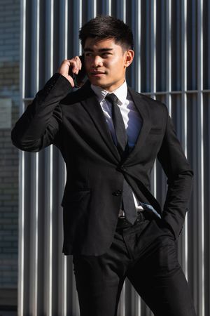 Smiling businessman speaking on smartphone in downtown