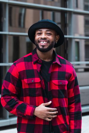 Cheerful Black man in stylish outfit on street