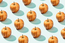 Half apple in row with whole apples