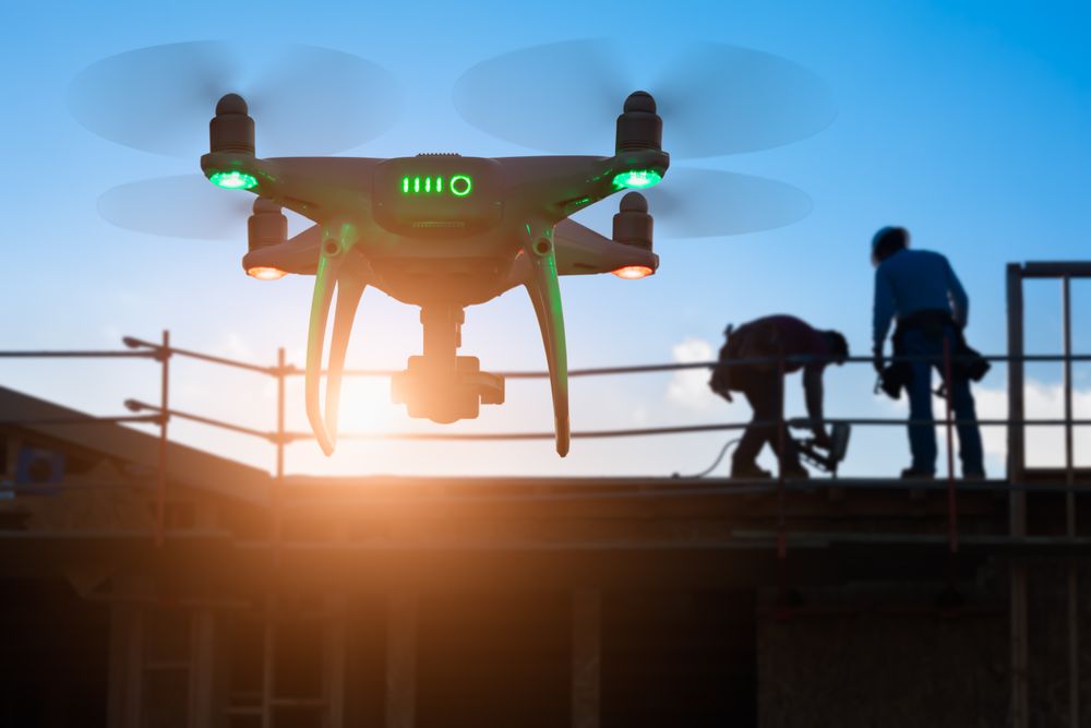 Silhouette of Unmanned Aircraft System Quadcopter Drone In The Air at Construction Site