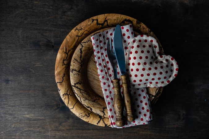 Valentine's day table setting of dotted napkin and heart decoration on rustic plate