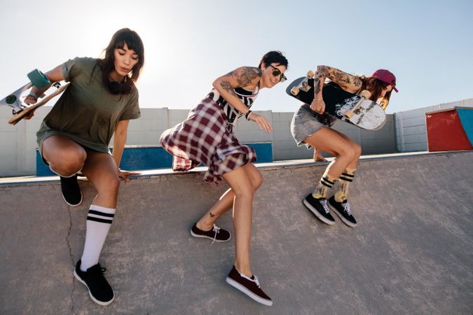Group of women running down from ramp at skate park