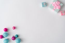 Christmas decorations and gifts on corners of light background