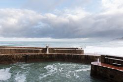 Rock breakwater with raging sea on cloudy weather