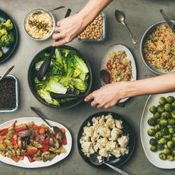 Vegan dinner table setting of healthy dishes in plates on table