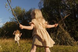 Little girls playing in countryside with sticks