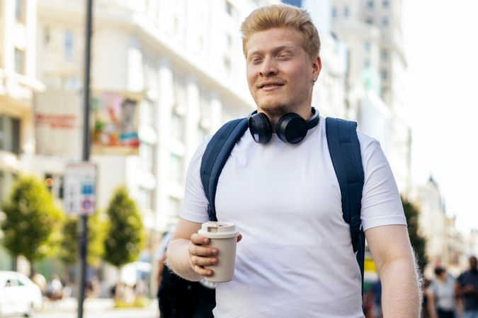 Young Latino man with albinism walking down the city street