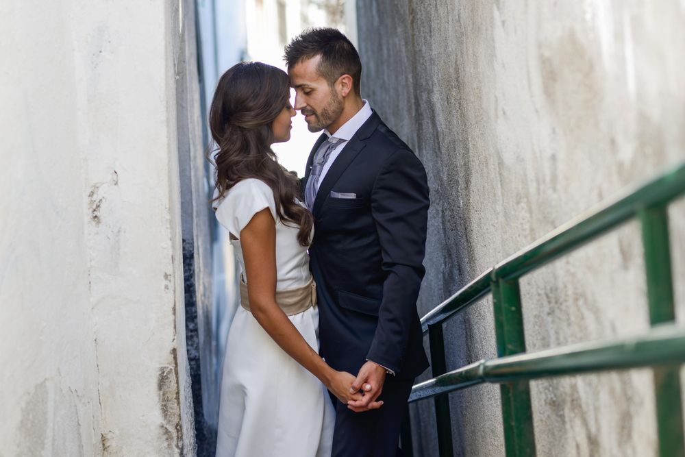 Newlyweds kissing on outdoor passageway